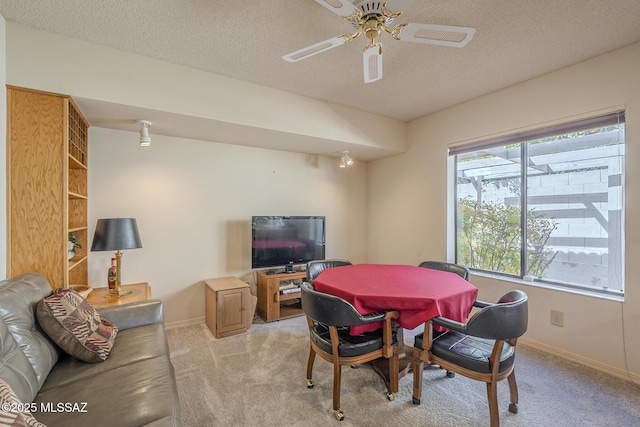 dining area with light colored carpet, ceiling fan, a textured ceiling, and baseboards