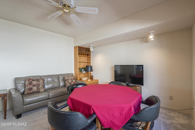 living area with carpet floors, built in shelves, a ceiling fan, and baseboards