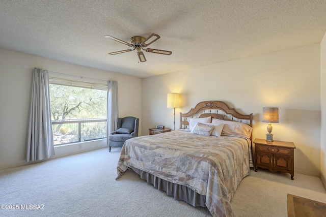 carpeted bedroom with ceiling fan and a textured ceiling