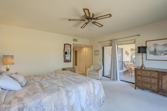 carpeted bedroom with access to outside, visible vents, ceiling fan, and a textured ceiling