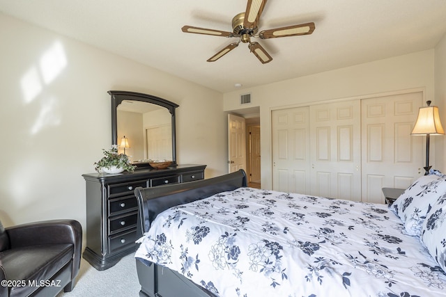 carpeted bedroom featuring ceiling fan, visible vents, and a closet