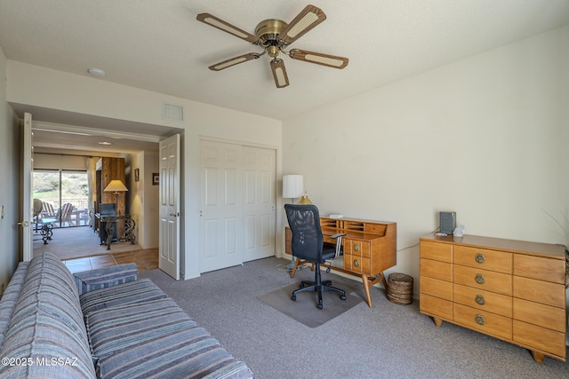 carpeted home office featuring ceiling fan and visible vents