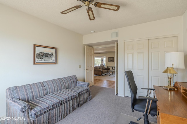 office space featuring ceiling fan, a textured ceiling, carpet, and visible vents