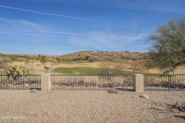 view of yard with view of golf course and fence