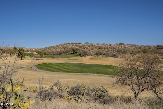 surrounding community with golf course view and a lawn