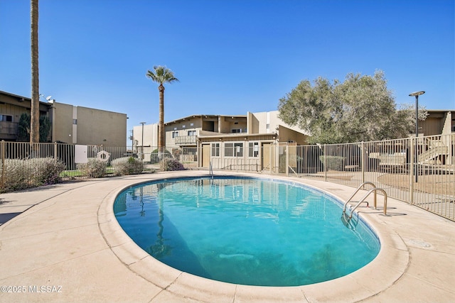 community pool with a patio area, a residential view, and fence