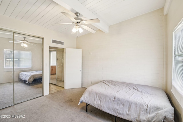 carpeted bedroom featuring a ceiling fan, visible vents, beamed ceiling, and brick wall