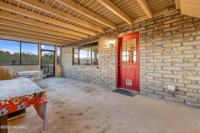 view of exterior entry with a patio area