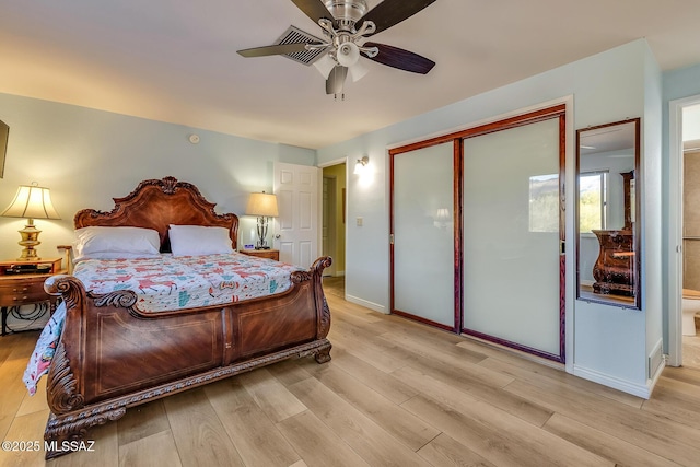 bedroom with a closet, ceiling fan, light wood-type flooring, and baseboards