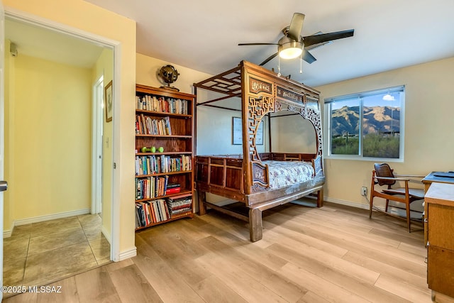 bedroom featuring ceiling fan, baseboards, and wood finished floors