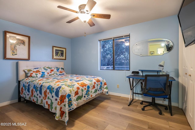 bedroom with a ceiling fan, baseboards, and wood finished floors