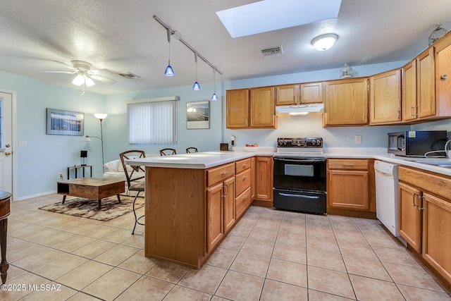 kitchen featuring visible vents, black appliances, under cabinet range hood, a peninsula, and light tile patterned floors