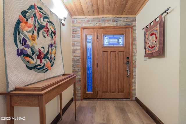 foyer entrance featuring wooden ceiling, wood finished floors, and baseboards