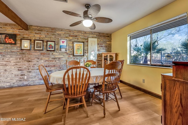 dining space with beamed ceiling, baseboards, light wood-type flooring, and ceiling fan