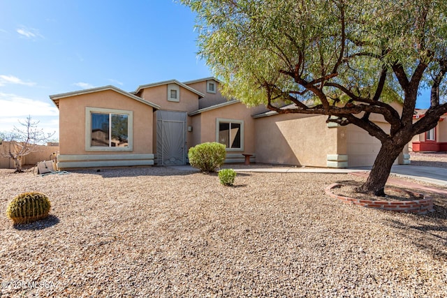 view of front of home with driveway, entry steps, a garage, and stucco siding