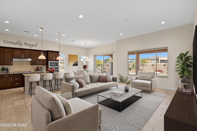 living room with recessed lighting, visible vents, baseboards, and an inviting chandelier