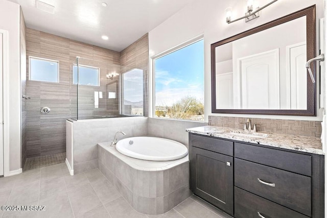 full bathroom featuring a walk in shower, a bath, vanity, and tile patterned floors