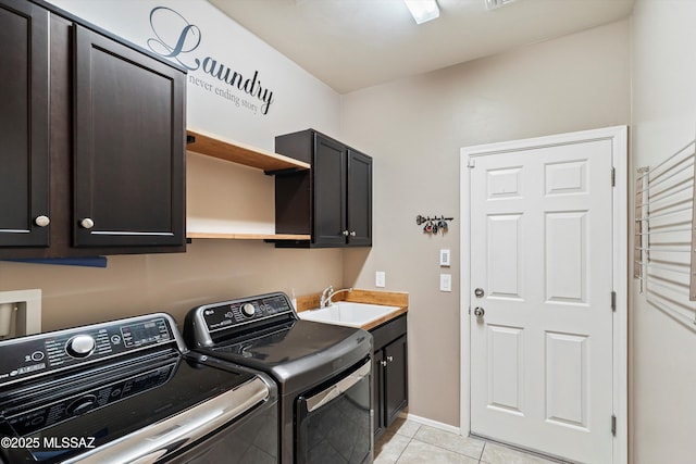 laundry room featuring light tile patterned flooring, cabinets, sink, and separate washer and dryer