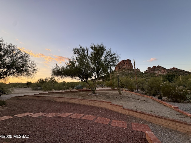 yard at dusk featuring a mountain view