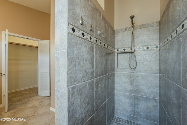 bathroom with tile patterned flooring and a tile shower