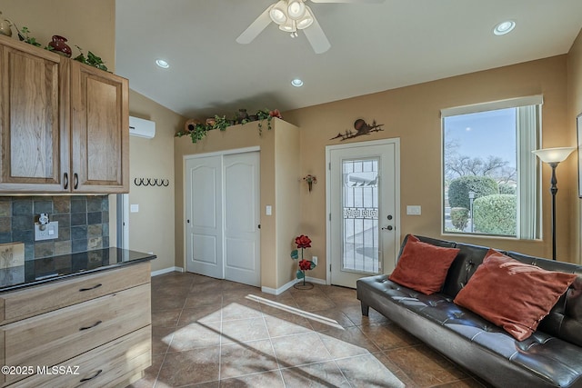 living area with light tile patterned floors, recessed lighting, a wall mounted AC, ceiling fan, and baseboards