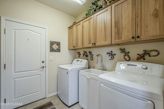 clothes washing area featuring cabinet space, light tile patterned flooring, a sink, and washing machine and clothes dryer