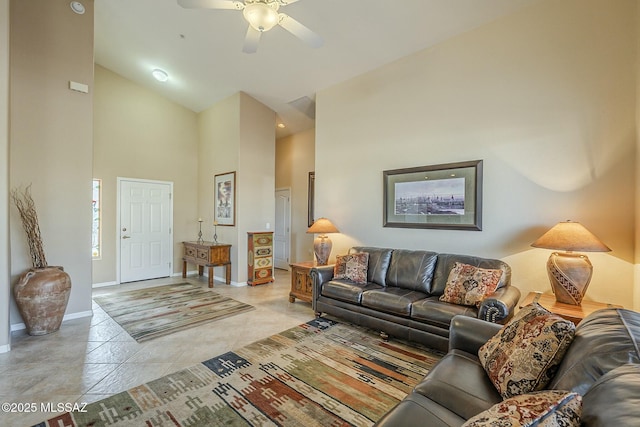 living area with high vaulted ceiling, ceiling fan, baseboards, and light tile patterned floors