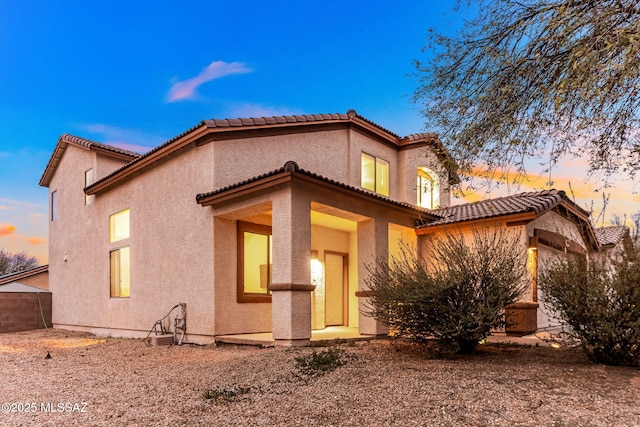 rear view of house featuring stucco siding