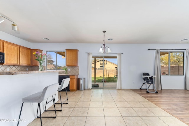 kitchen with plenty of natural light, tasteful backsplash, and light tile patterned floors