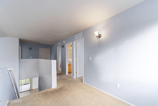 carpeted empty room with visible vents and baseboards