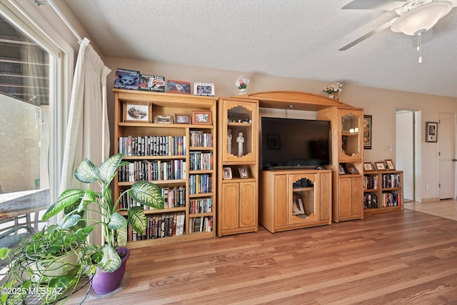 interior space with ceiling fan, light hardwood / wood-style floors, and a textured ceiling