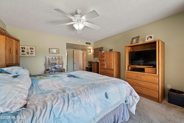 bedroom featuring ceiling fan, carpet flooring, and a textured ceiling