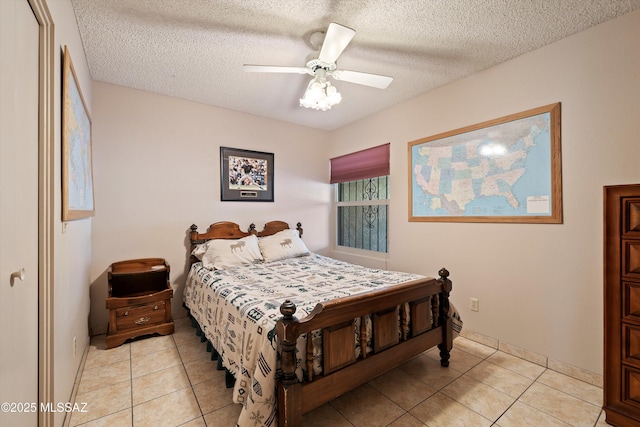 bedroom with a textured ceiling, ceiling fan, and light tile patterned floors