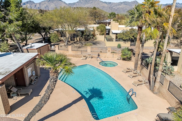 view of pool featuring a mountain view, an outdoor bar, a hot tub, and a patio area