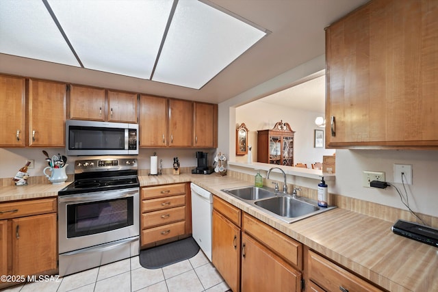 kitchen featuring sink, appliances with stainless steel finishes, and light tile patterned floors