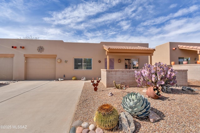 pueblo revival-style home featuring a garage