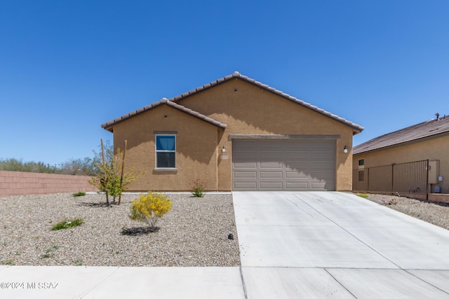 view of front of property featuring a garage, fence, concrete driveway, and stucco siding