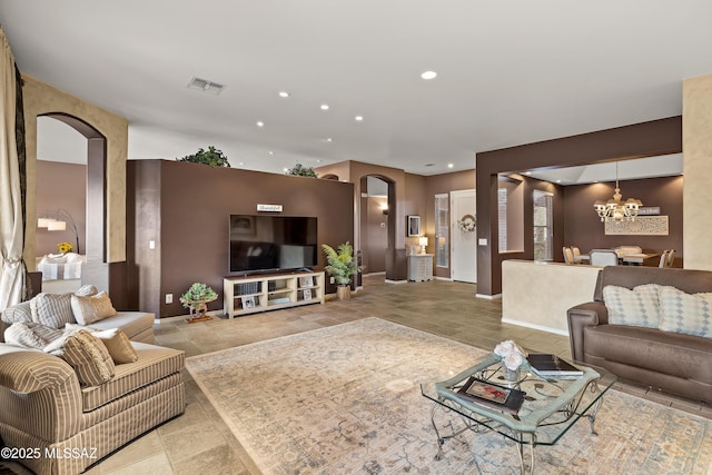 living room with arched walkways, recessed lighting, visible vents, baseboards, and an inviting chandelier