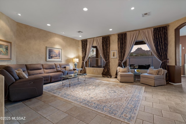 living room with a wealth of natural light, visible vents, and recessed lighting