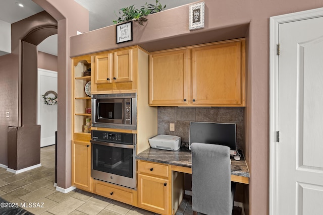 office featuring baseboards, arched walkways, and built in study area