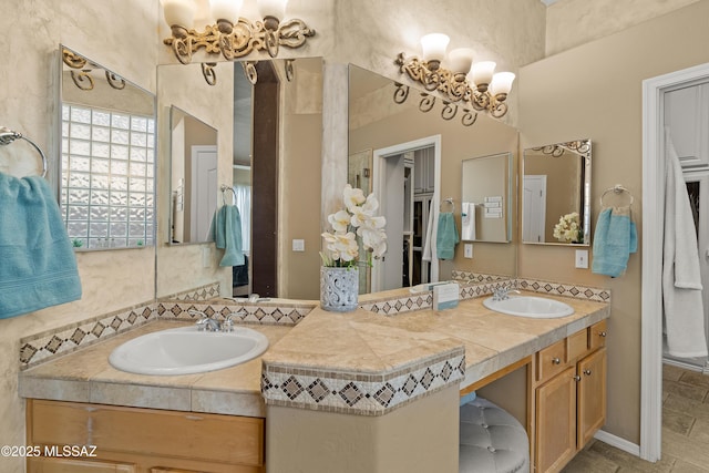 full bath featuring double vanity, an inviting chandelier, and a sink