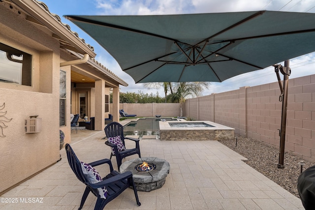 view of patio featuring an in ground hot tub, an outdoor fire pit, a fenced backyard, and a fenced in pool