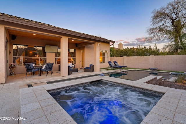 view of swimming pool with a fenced in pool, a patio area, fence, and an in ground hot tub