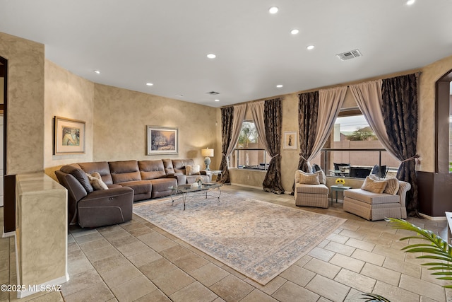 living area with baseboards, visible vents, and recessed lighting