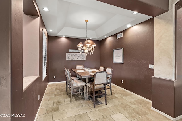 dining room featuring recessed lighting, a raised ceiling, stone finish flooring, and baseboards