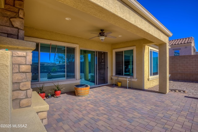 view of patio with fence and a ceiling fan