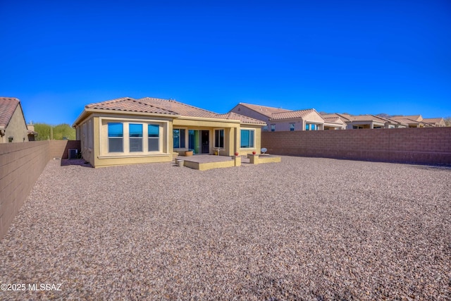 back of property with a tile roof, a patio, a fenced backyard, and stucco siding