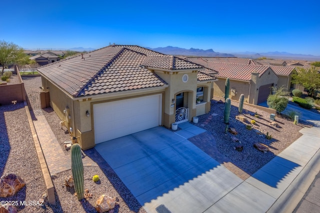 view of front of house featuring a garage, concrete driveway, a tile roof, and stucco siding