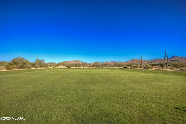 surrounding community featuring a lawn and a mountain view