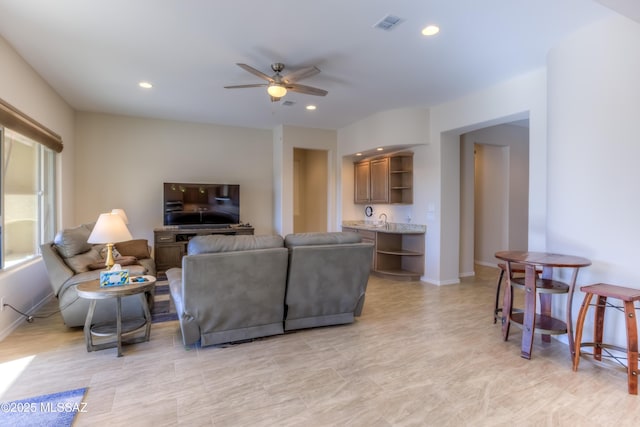 living room featuring baseboards, visible vents, a ceiling fan, and recessed lighting